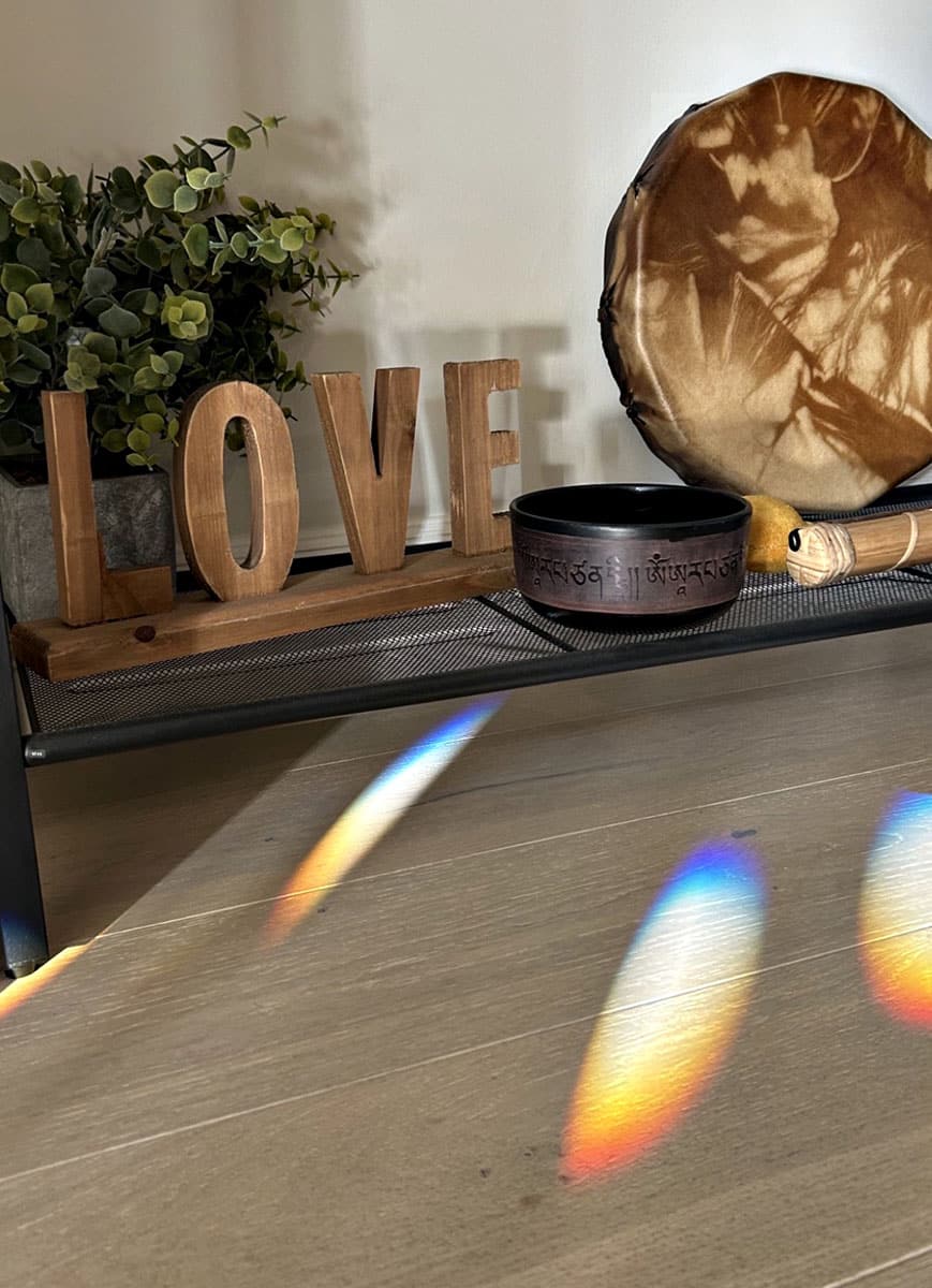 Wooden 'LOVE' letters on shelf with drum and singing bowl